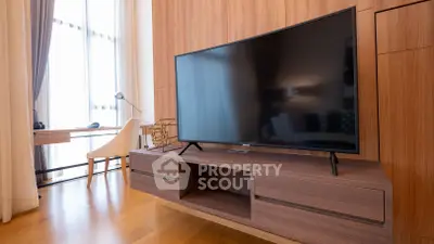 Modern living room with sleek TV and stylish wooden furniture, perfect for contemporary living.