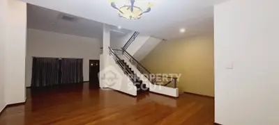 Spacious modern living room with elegant staircase and wooden flooring