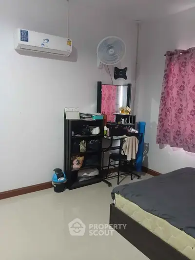 Cozy bedroom with air conditioning and stylish vanity setup, perfect for comfort and relaxation.