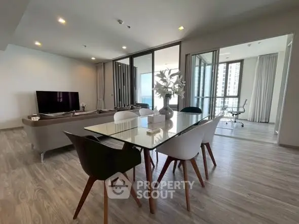 Spacious modern living room with glass dining table and city view