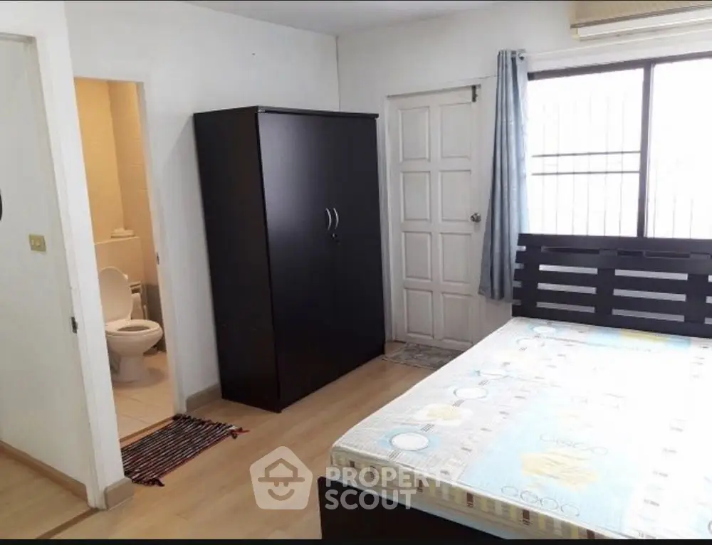 Spacious bedroom with ensuite bathroom and large window for natural light.
