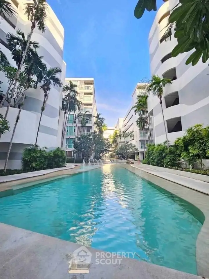 Luxurious condominium with stunning pool and lush greenery, perfect for relaxation and modern living.