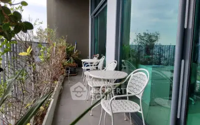 Spacious balcony with outdoor seating and lush greenery, perfect for relaxation and enjoying the view.