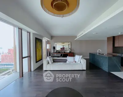 Luxurious modern living room with open kitchen and stunning city view, featuring elegant decor and spacious layout.