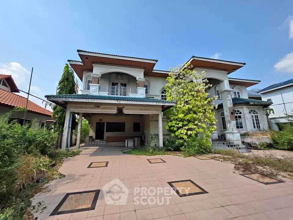 Spacious two-story house with large driveway and lush greenery, perfect for family living.