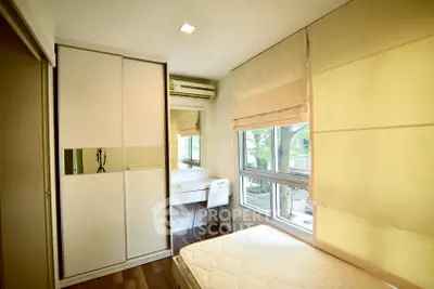 Cozy bedroom with large window, built-in wardrobe, and study desk in modern apartment.