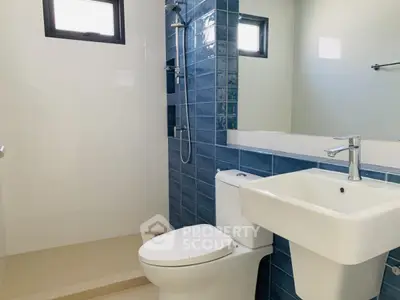 Modern bathroom with blue tile accent wall and sleek fixtures