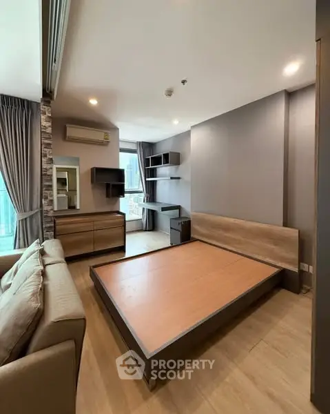 Modern bedroom with sleek furniture and city view, perfect for urban living.