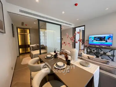 Modern open-plan living and dining area with stylish decor and a cozy bedroom view.