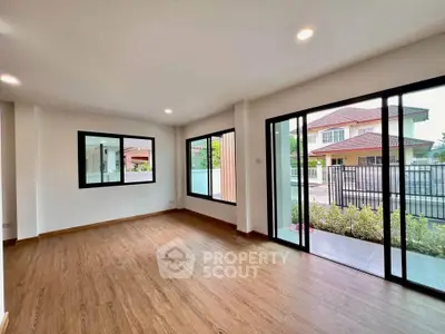 Spacious living room with large windows and wooden flooring in modern home