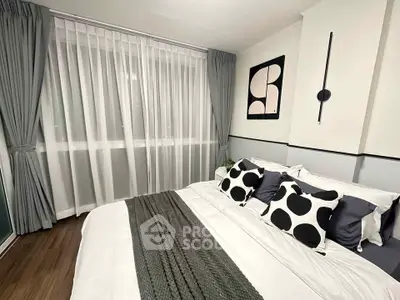 Modern bedroom with stylish decor and large window, featuring elegant curtains and cozy bedding.