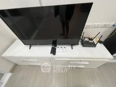 Modern living room setup with sleek TV and white console table, perfect for entertainment.