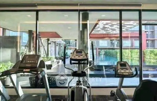 Modern gym with pool view in luxury residential complex