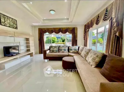 Spacious living room with elegant decor and large windows offering garden views.