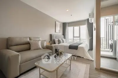 Modern studio apartment with cozy living area and balcony view