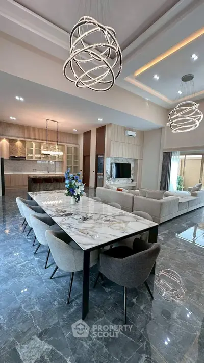 Luxurious open-plan living and dining area with modern lighting and marble flooring.