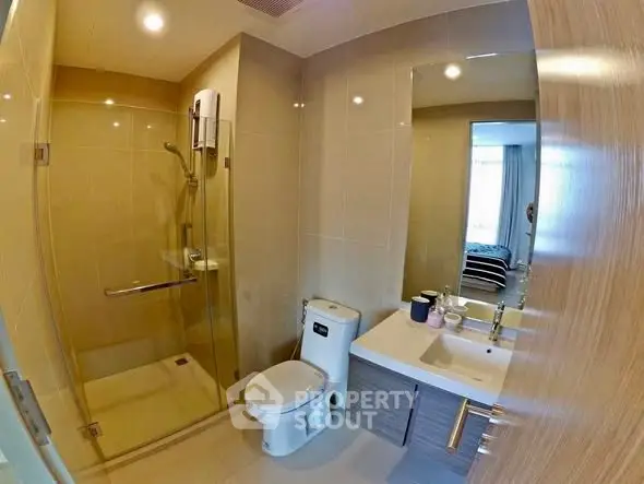 Modern bathroom with glass shower and sleek fixtures in a contemporary apartment.