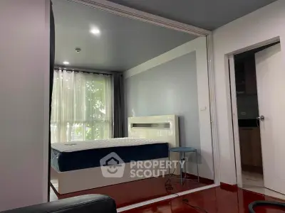 Modern bedroom with large window and stylish decor in a contemporary apartment.