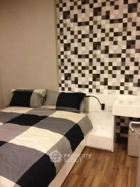 Modern bedroom with stylish checkered wall and cozy bedding