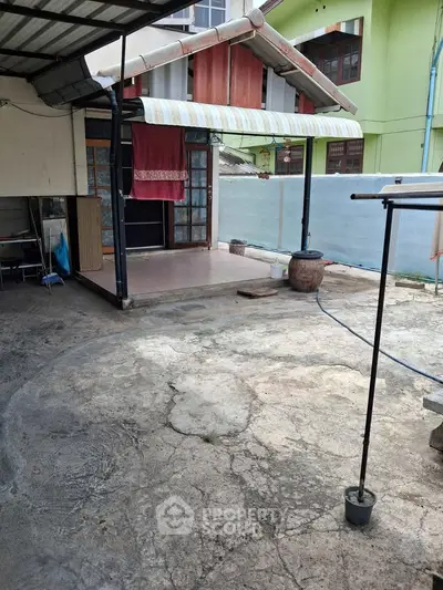 Charming rustic exterior with covered patio and vintage awning, perfect for outdoor relaxation.