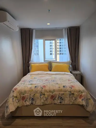 Cozy bedroom with floral bedding and city view, perfect for urban living.