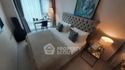 Luxurious bedroom with elegant decor and natural light, featuring a plush bed and stylish workspace.