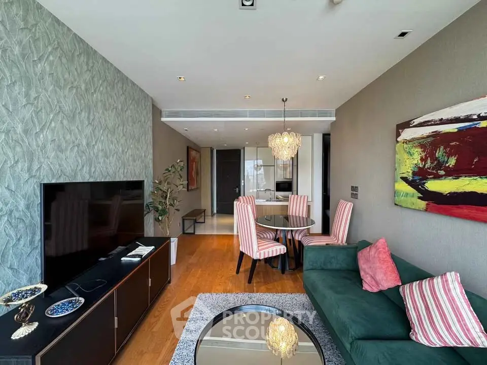 Stylish living room with modern decor, green sofa, and vibrant artwork in a luxury apartment.