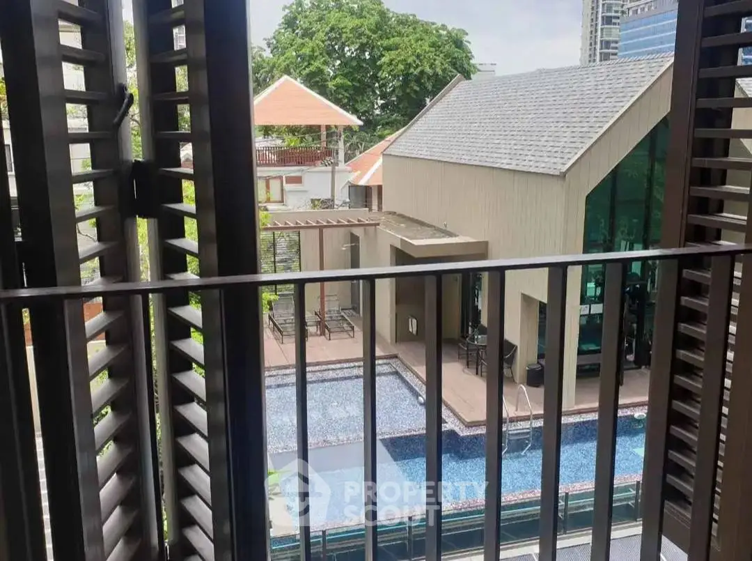 Chic urban balcony view overlooking modern pool and stylish building.