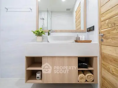 Modern bathroom with wooden vanity and large mirror in a stylish home.