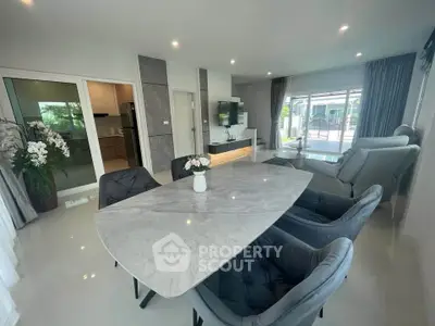 Spacious modern living room with elegant dining area and large windows offering natural light.