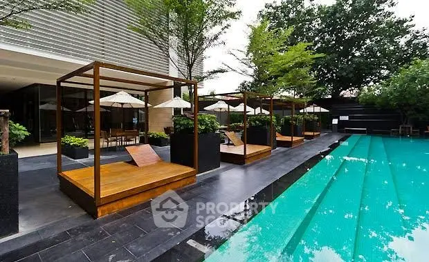 Luxurious outdoor pool area with stylish cabanas and lush greenery.
