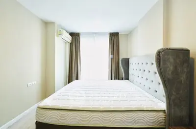 Spacious bedroom with elegant bed and natural light, perfect for relaxation.