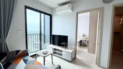 Modern living room with city view, featuring sleek furniture and natural light.