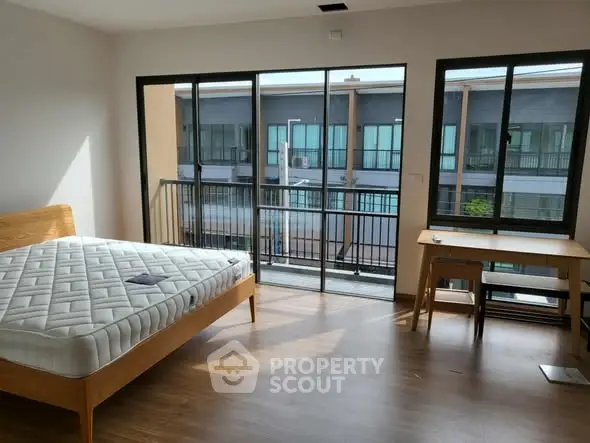 Spacious bedroom with balcony and modern furnishings in a stylish apartment.