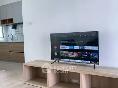 Modern living room with sleek TV and stylish kitchen in open layout