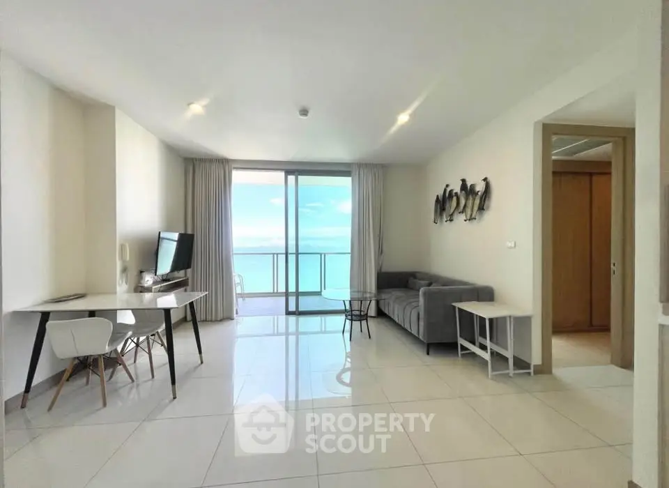 Spacious living room with ocean view, modern furniture, and natural light in a luxury apartment.