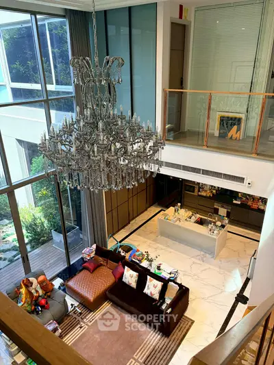 Luxurious living room with grand chandelier and modern decor in a spacious open layout.