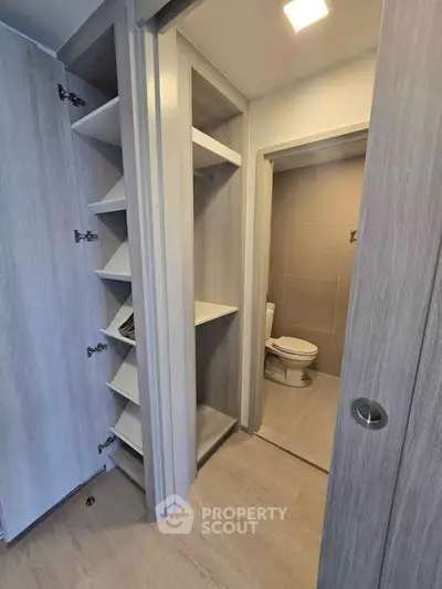 Modern bathroom with wooden storage shelves and sleek design