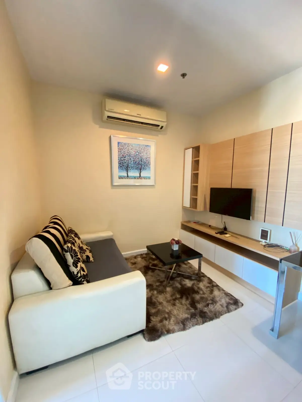 Cozy living room with modern decor and air conditioning, perfect for relaxation.