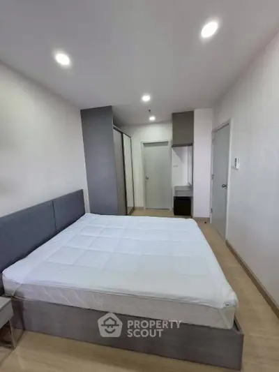 Modern bedroom with sleek design and ample storage in a stylish apartment.