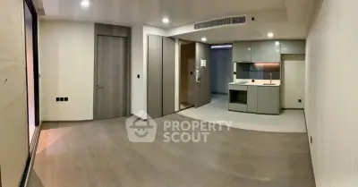 Modern open-plan living room with sleek kitchen design and wooden flooring