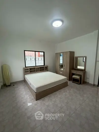 Spacious bedroom with modern furniture and natural light