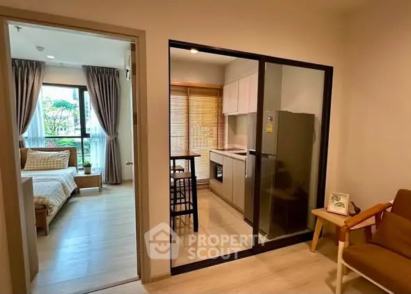 Modern apartment with open kitchen and cozy living area, featuring large windows and stylish decor.