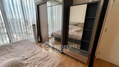 Modern bedroom with floor-to-ceiling windows and mirrored wardrobe offering city views.