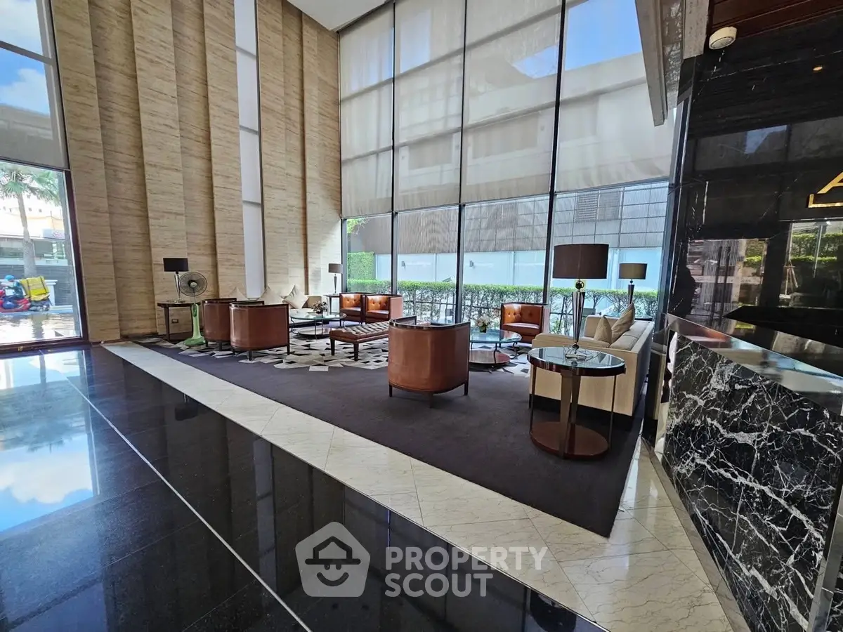 Luxurious modern lobby with high ceilings and elegant seating area in upscale building.