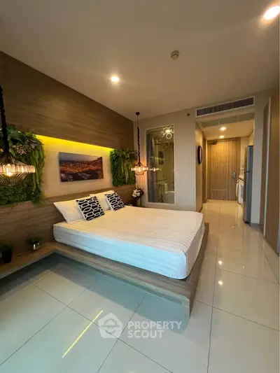 Modern bedroom with stylish decor and ambient lighting in a contemporary apartment.