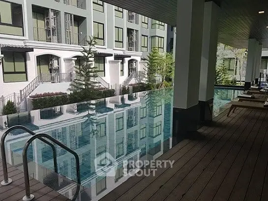 Luxurious apartment complex with stunning poolside view and modern architecture.