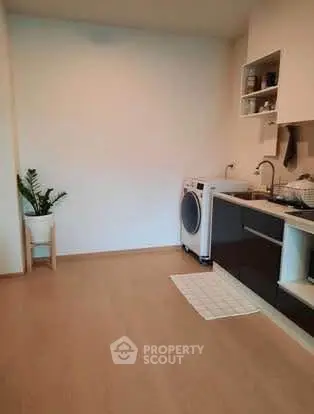 Modern kitchen with sleek cabinets and washing machine, perfect for urban living.