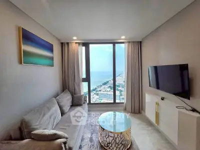 Luxurious living room with stunning ocean view, modern decor, and elegant furnishings.