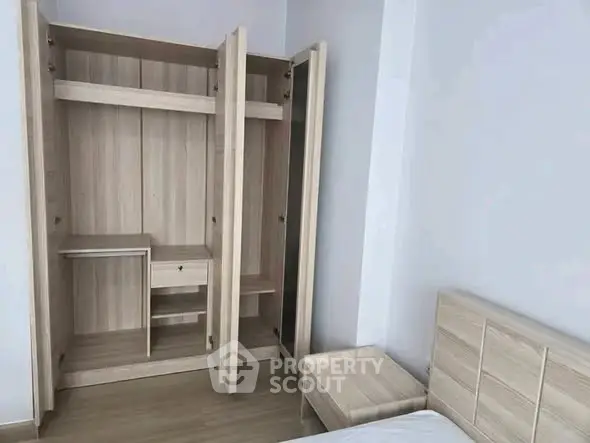 Spacious bedroom with modern wooden wardrobe and bed, perfect for stylish living.